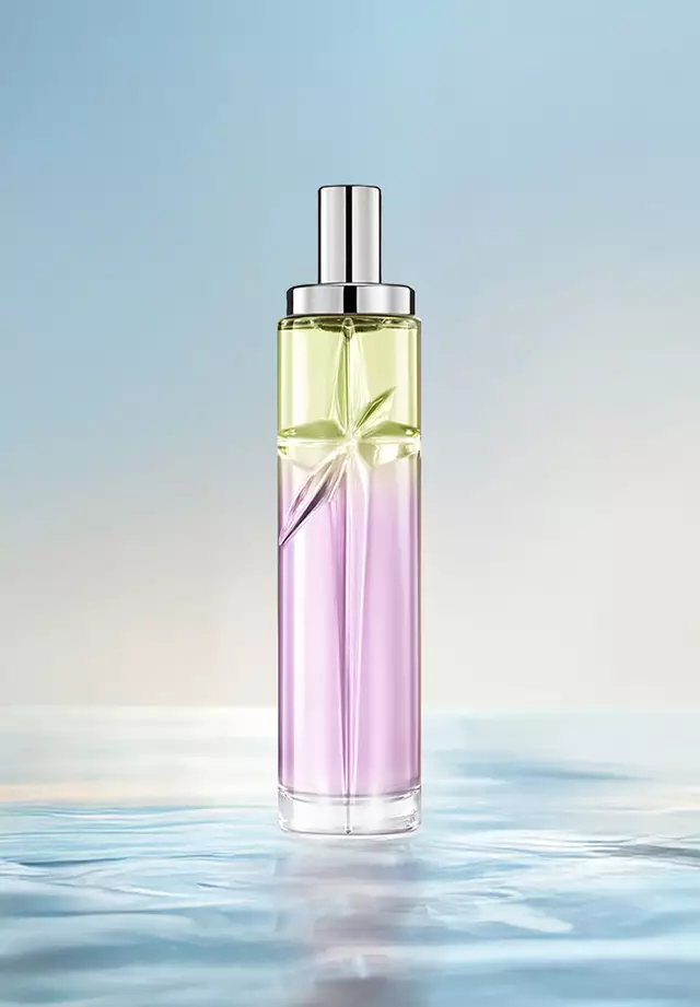 Ricetta di layering Gourmet Berry Starlicious: flacone alto con sfumatura verde chiaro e rosa su acqua increspata su sfondo blu tenue. Profumo aspro, dolce e succoso con dolcezza nocciolata; 3 spruzzi Berry Licorice, 1 Pistachio Praline.
